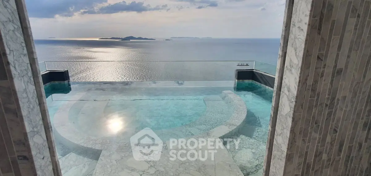 Luxurious infinity pool with breathtaking ocean view from marble terrace.