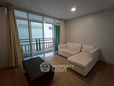 Modern living room with white sectional sofa and balcony access