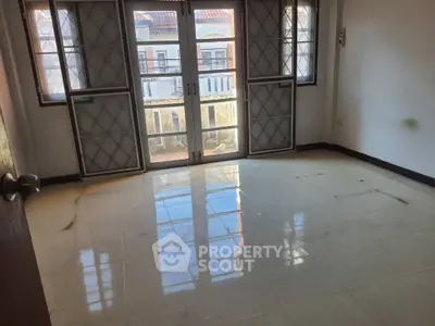 Spacious empty room with large windows and tiled floor, perfect for customization.