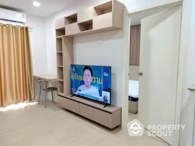 Modern living room with built-in TV unit and study area, featuring sleek design and neutral tones.