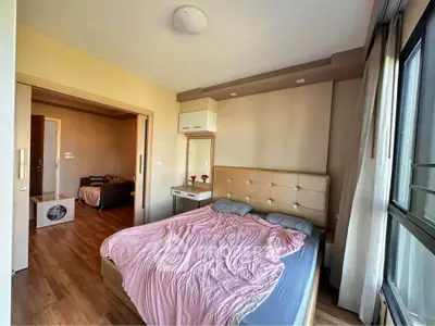 Spacious bedroom with large windows and cozy decor in modern apartment