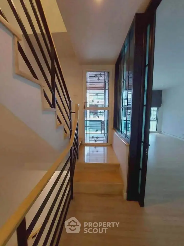 Modern staircase with sleek railing leading to bright open living space