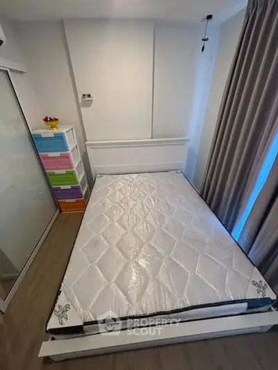 Cozy bedroom with a minimalist design featuring a bed and colorful storage drawers.