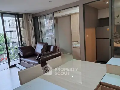 Modern open-plan living room with sleek kitchen and balcony view