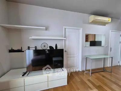 Modern living room with sleek TV setup and air conditioning in stylish apartment.