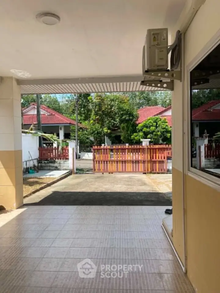 Charming residential property with tiled driveway and red fence, ideal for family living.