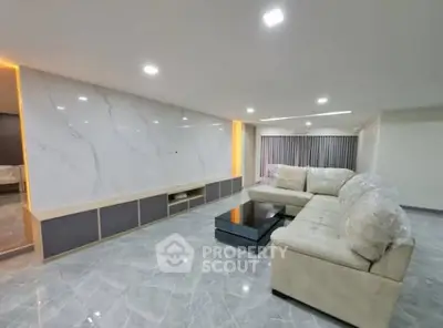 Spacious modern living room with elegant marble flooring and plush sectional sofa.