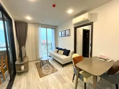 Modern living room with balcony view, stylish decor, and open layout in a high-rise apartment.