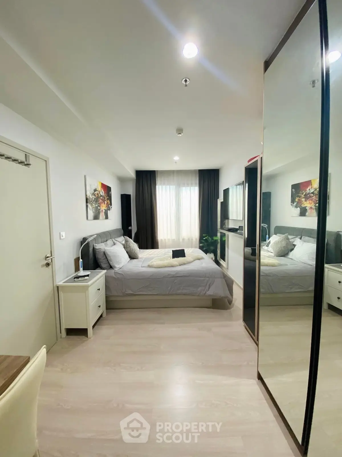 Modern bedroom with large mirror and stylish decor in a cozy apartment