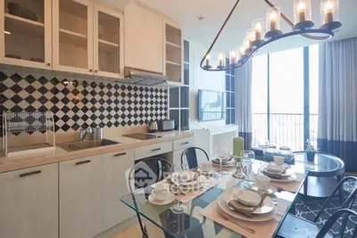 Modern kitchen with dining area, featuring stylish cabinetry and elegant lighting.