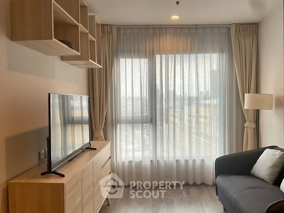 Modern living room with large window, stylish furniture, and natural light