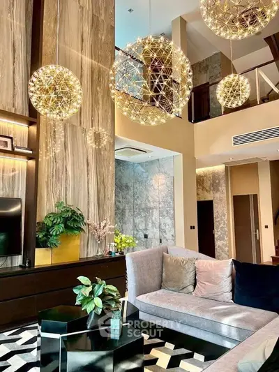 Luxurious modern living room with high ceilings and elegant lighting fixtures.