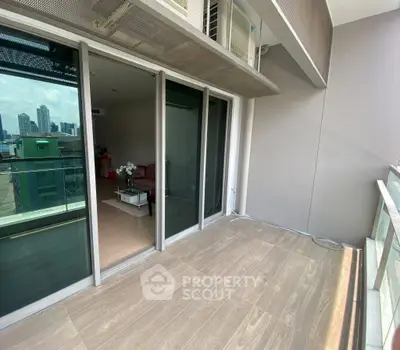 Spacious balcony with city view and modern interior glimpse, perfect for urban living.