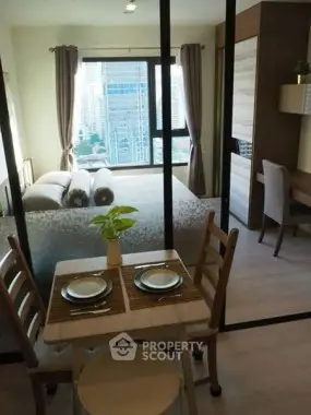 Modern studio apartment with city view, featuring cozy dining area and stylish bedroom.