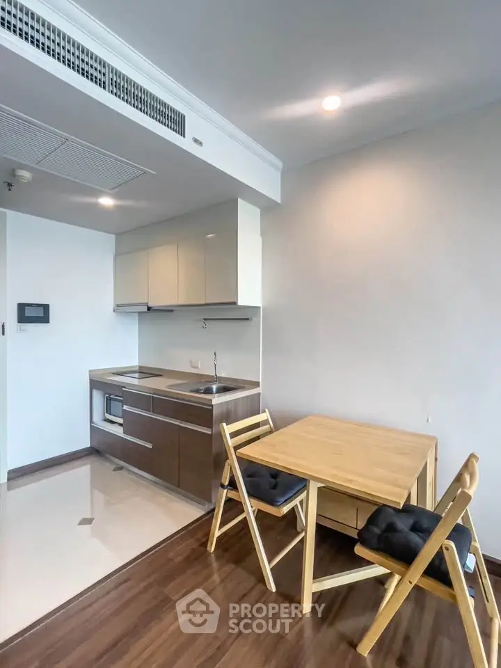 Modern kitchen with sleek cabinetry and dining area in a stylish apartment