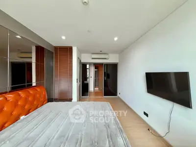 Spacious modern bedroom with sleek design and wall-mounted TV