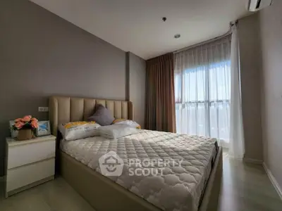 Spacious bedroom with modern decor and large window offering natural light.