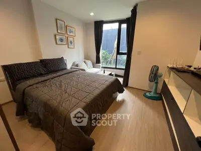 Cozy bedroom with modern decor, large window, and stylish furnishings in a contemporary apartment.