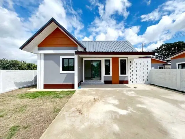 Charming modern single-story house with spacious driveway and vibrant exterior design.