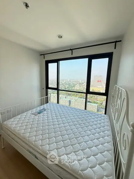 Spacious bedroom with stunning city view and large windows in modern apartment.