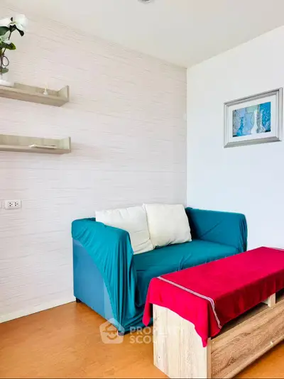Cozy living room with teal sofa, red coffee table, and modern decor