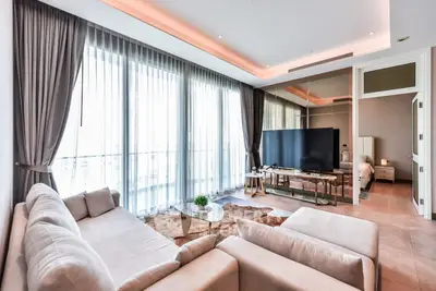 Luxurious living room with floor-to-ceiling windows and modern decor in a high-end apartment.