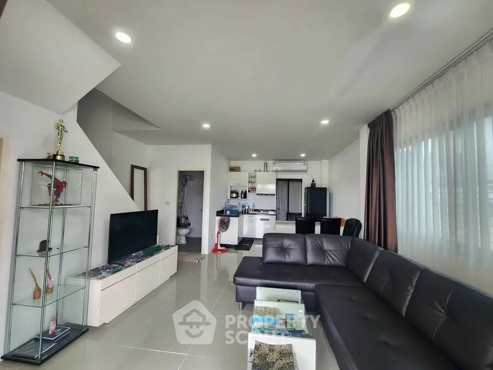 Spacious modern living room with sleek furniture and open kitchen layout