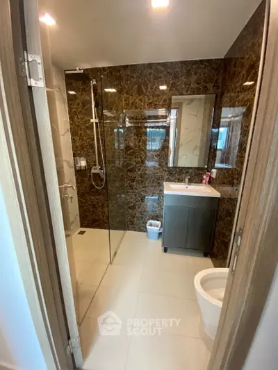 Luxurious modern bathroom with glass shower and elegant marble walls