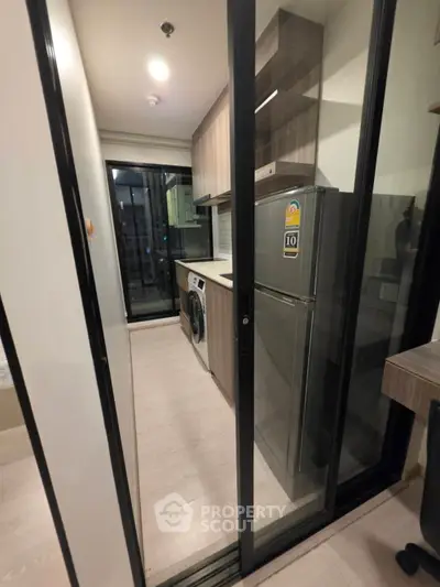 Modern kitchen with sleek appliances and sliding glass door in urban apartment