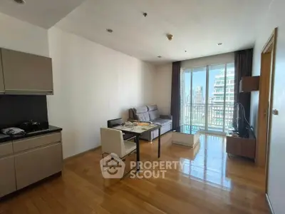 Modern living room with open kitchen and city view balcony in high-rise apartment.