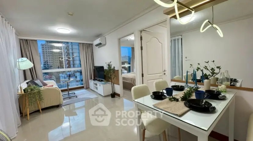 Modern open-plan living and dining area with city view, stylish decor, and natural light.