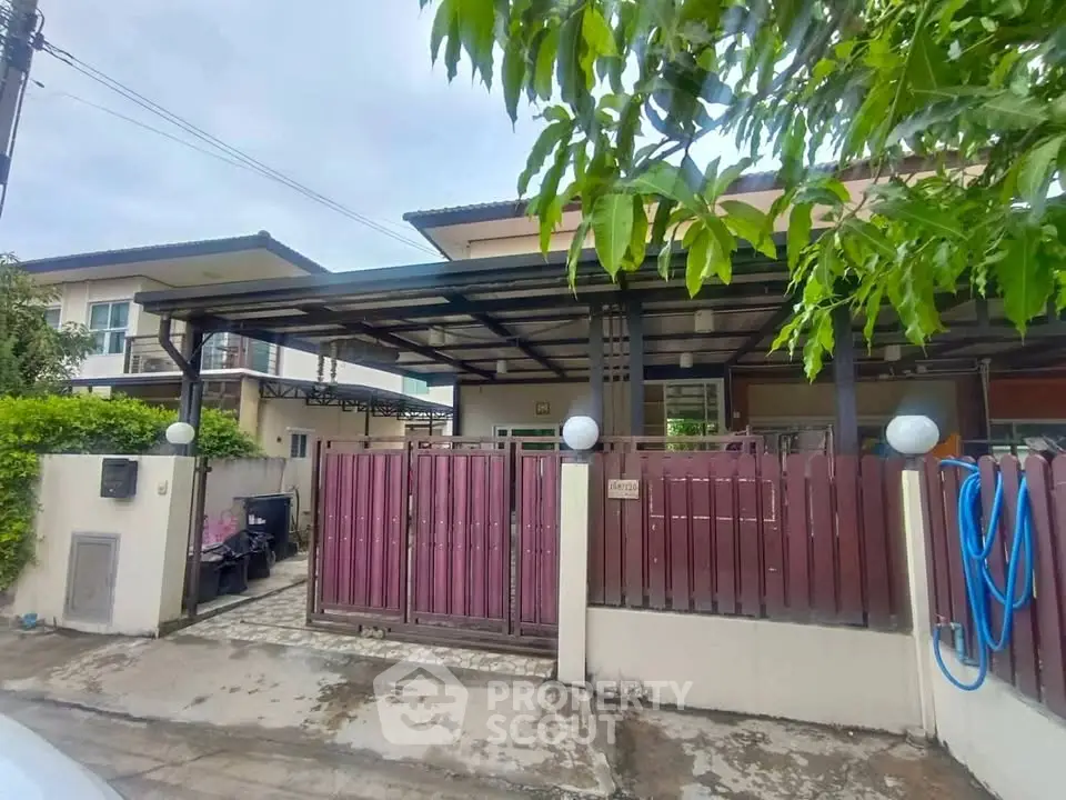 Charming suburban house with gated entrance and covered parking area, perfect for family living.