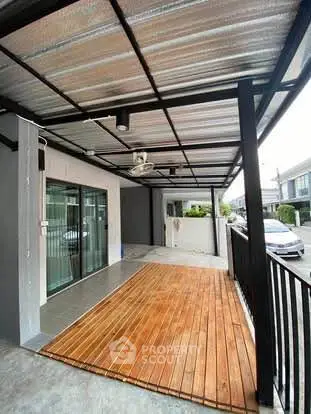 Modern covered patio with wooden deck and ceiling fan in residential area.