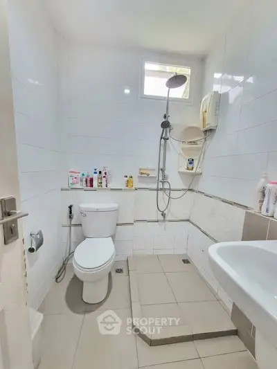 Compact bathroom with shower and modern fixtures, ideal for efficient space use.