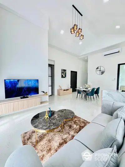 Spacious and modern living room with high ceilings, elegant marble coffee table, plush sofa, and a sleek dining area in the background, perfect for entertaining.