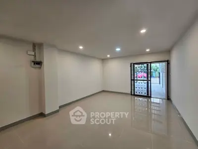 Spacious empty room with glossy tiled floor and large window for natural light.