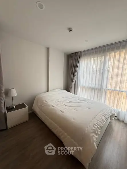 Cozy bedroom with modern decor and large window for natural light