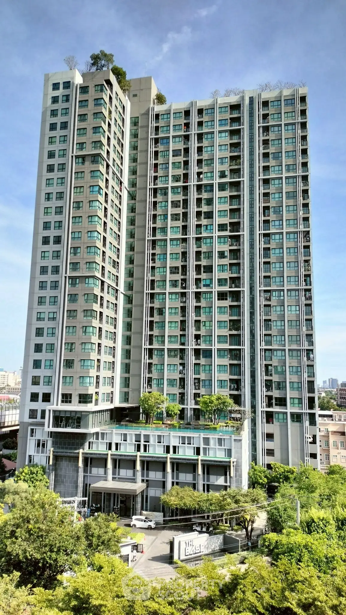 Stunning high-rise residential building with lush greenery and modern architecture.