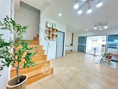 Spacious modern living room with staircase and large windows for natural light.