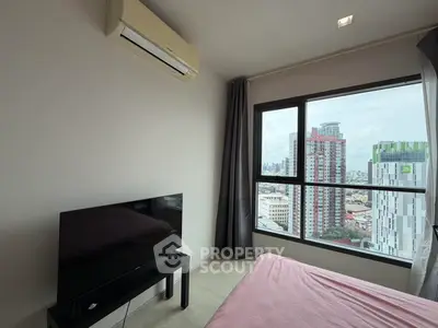 Modern bedroom with city view, featuring air conditioning and sleek TV setup.