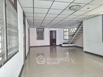 Spacious open-plan living area with tiled flooring and staircase, ideal for modern living.