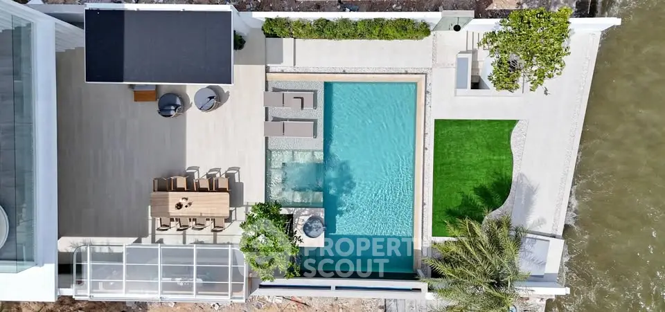 Luxurious waterfront property with private pool and spacious outdoor dining area.