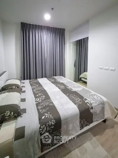 Cozy bedroom with elegant decor and large window, perfect for relaxation and comfort.