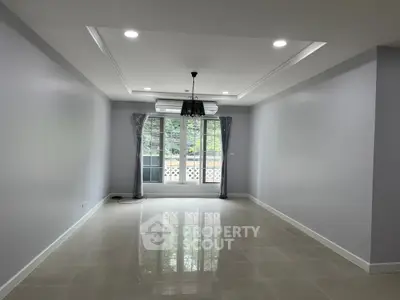 Spacious empty living room with large windows and modern lighting
