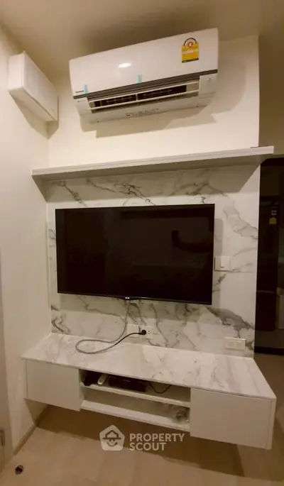 Modern living room with wall-mounted TV and air conditioning unit