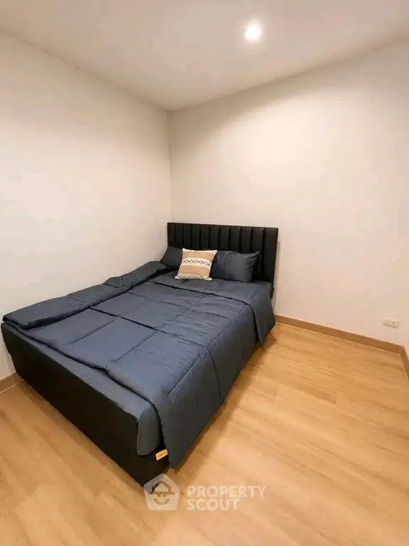 Cozy bedroom with modern bed and wooden flooring, perfect for relaxation.