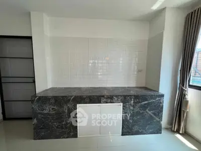 Modern kitchen with marble countertop and white subway tile backsplash