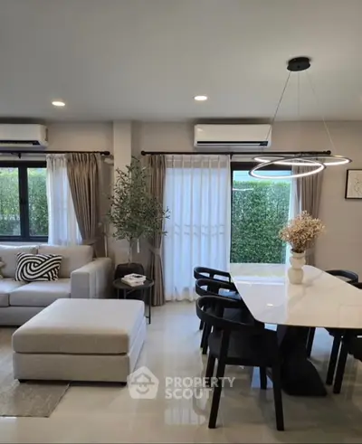 Modern living room with stylish decor and large windows offering natural light.