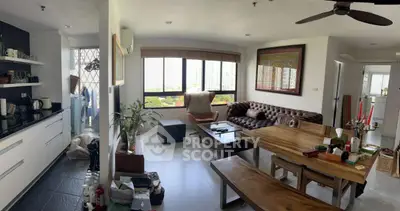 Spacious living room with modern decor and large windows offering city views.