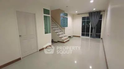 Spacious modern living room with staircase and large windows